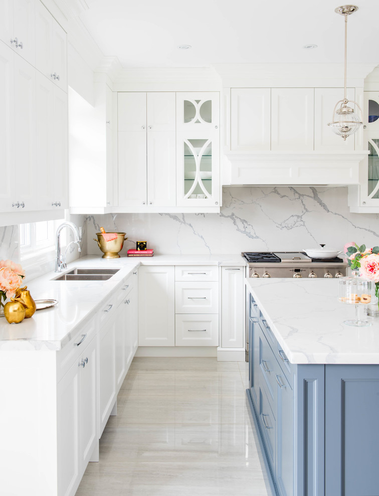 Photo of a mid-sized transitional l-shaped open plan kitchen in San Diego with a double-bowl sink, shaker cabinets, white cabinets, white splashback, stone slab splashback, stainless steel appliances, marble floors, with island, marble benchtops and white floor.
