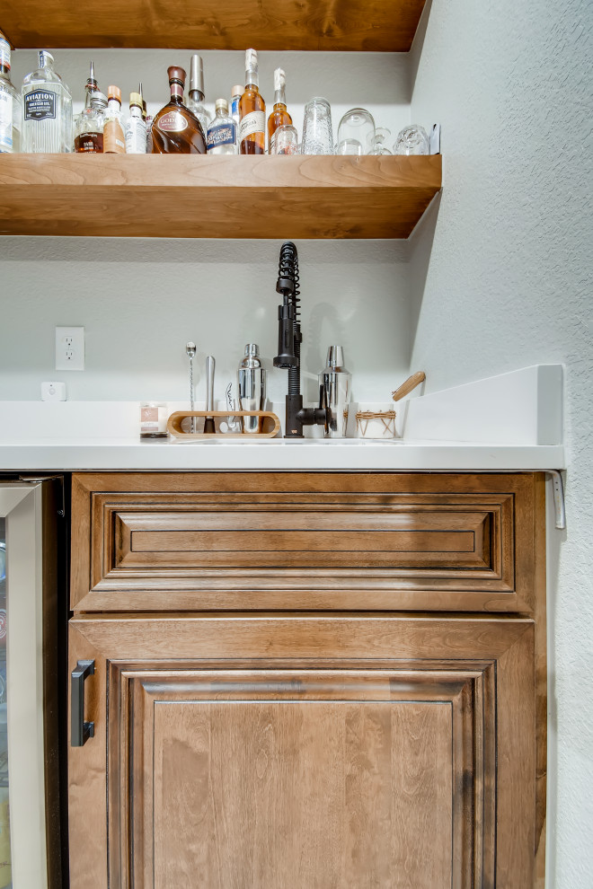 Small modern single-wall wet bar in Denver with an undermount sink, brown cabinets, quartzite benchtops, vinyl floors, grey floor and white benchtop.