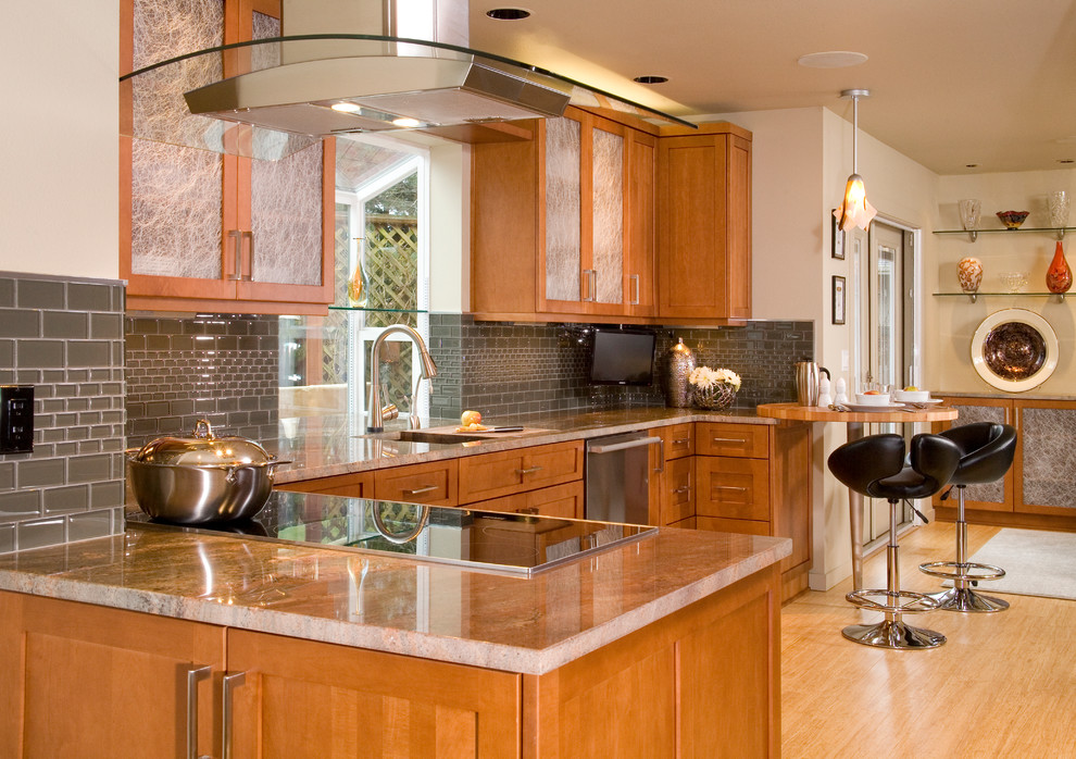 Inspiration for a mid-sized transitional l-shaped light wood floor eat-in kitchen remodel in Seattle with an undermount sink, shaker cabinets, gray backsplash, glass tile backsplash, stainless steel appliances, medium tone wood cabinets, granite countertops and no island