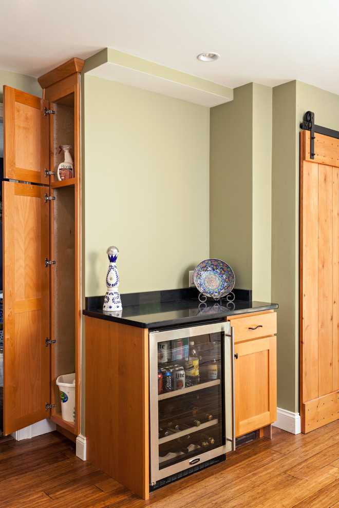 Example of a mid-sized transitional u-shaped bamboo floor eat-in kitchen design in Boston with an undermount sink, shaker cabinets, medium tone wood cabinets, recycled glass countertops, brown backsplash, stone tile backsplash, stainless steel appliances, green walls and an island