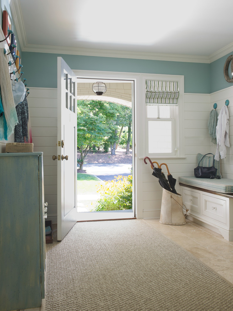Photo of a mid-sized beach style mudroom in DC Metro with blue walls, limestone floors and a single front door.