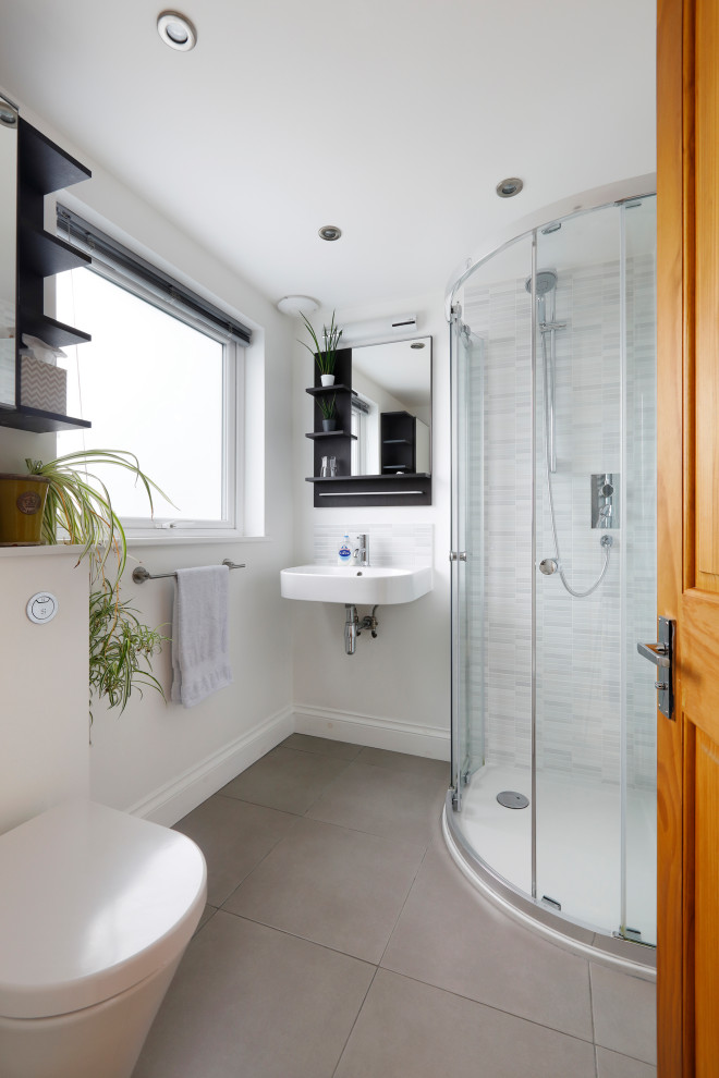 Пример оригинального дизайна: маленькая главная ванная комната в современном стиле с темными деревянными фасадами, открытым душем, инсталляцией, серой плиткой, плиткой мозаикой, белыми стенами, полом из керамической плитки, подвесной раковиной, серым полом, душем с раздвижными дверями, тумбой под одну раковину и подвесной тумбой для на участке и в саду