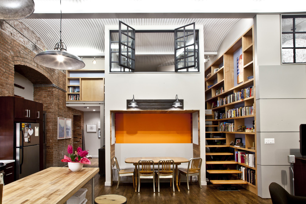 Photo of an industrial living room in New York with a library.