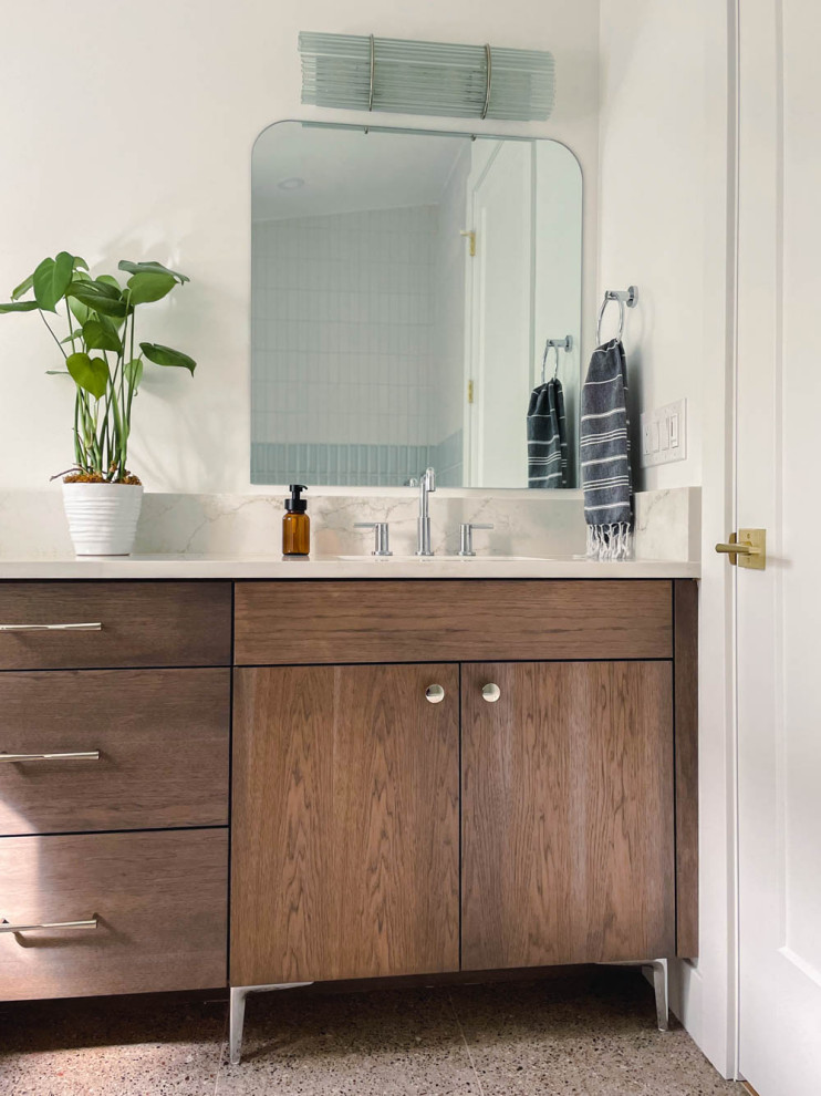 Design ideas for a mid-sized midcentury kids bathroom in Denver with flat-panel cabinets, brown cabinets, an alcove tub, an alcove shower, a one-piece toilet, multi-coloured tile, porcelain tile, white walls, porcelain floors, an undermount sink, engineered quartz benchtops, brown floor, a shower curtain, white benchtops, a double vanity and a built-in vanity.