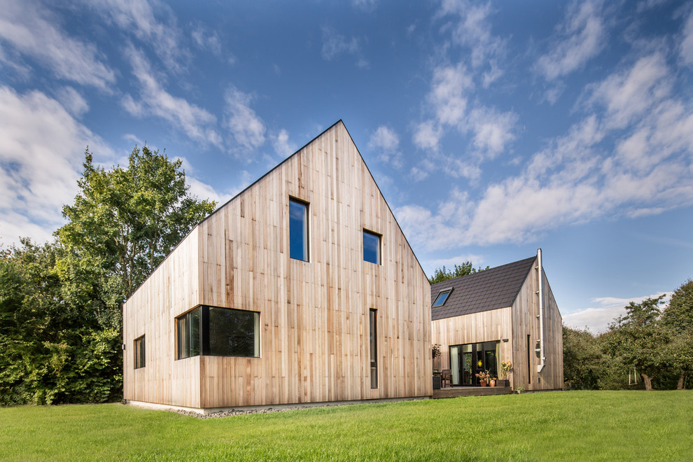 Große, Zweistöckige Moderne Holzfassade Haus mit brauner Fassadenfarbe und Satteldach in Hamburg