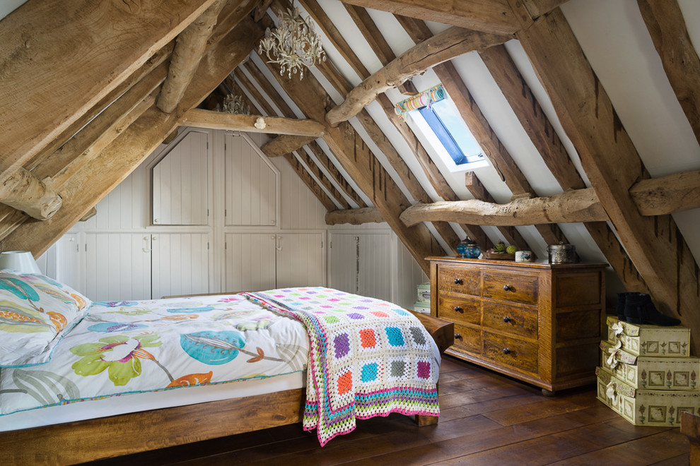 Country guest bedroom in Wiltshire with dark hardwood floors, white walls and brown floor.