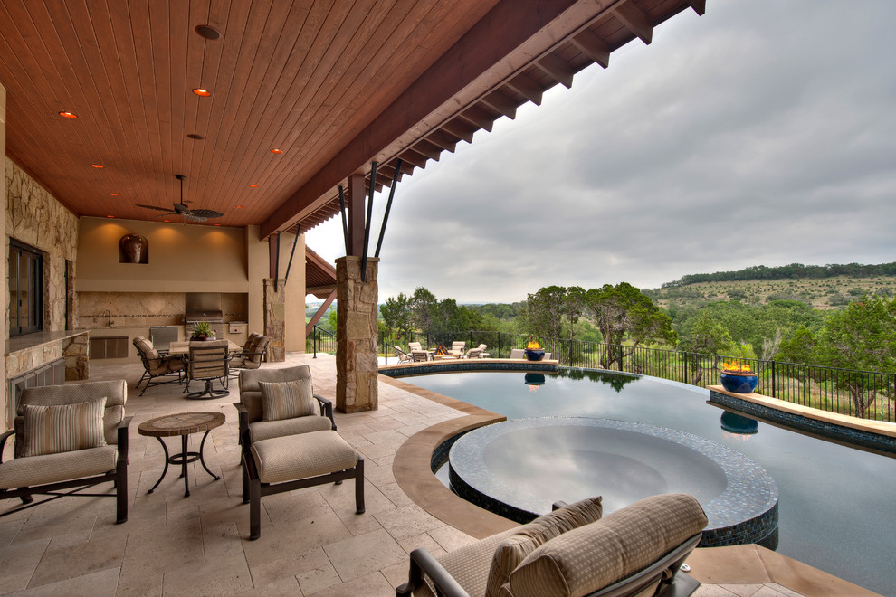 Photo of a large mediterranean backyard custom-shaped infinity pool in Austin with tile.