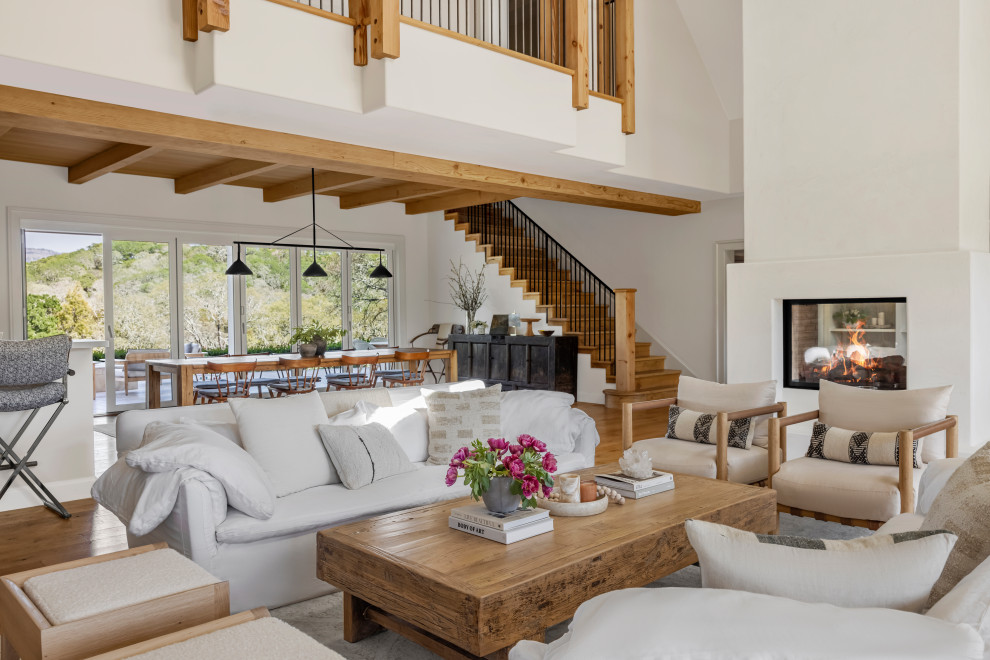 Стильный дизайн: гостиная комната в стиле кантри с двусторонним камином - последний тренд
