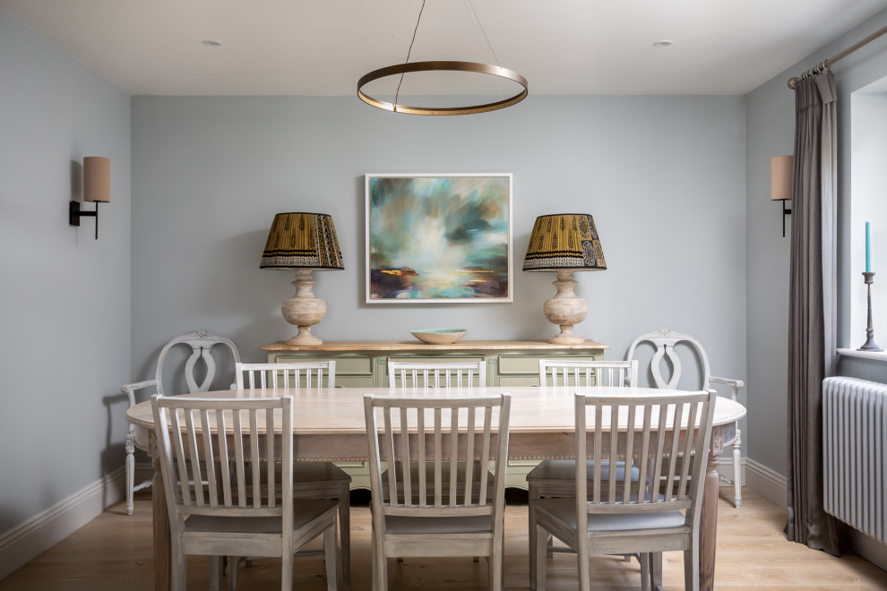 Mid-sized beach style separate dining room in Gloucestershire with grey walls, light hardwood floors and brown floor.