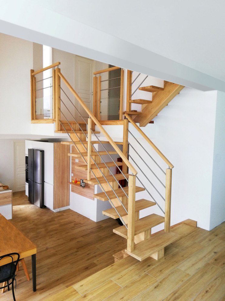 Inspiration pour un escalier minimaliste en U de taille moyenne avec des marches en bois, des contremarches en bois, un garde-corps en bois et palier.