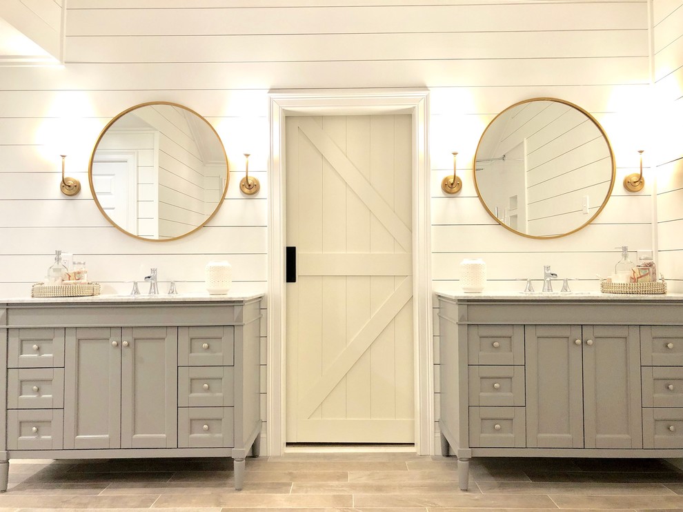 Design ideas for a large country master bathroom in Bridgeport with recessed-panel cabinets, grey cabinets, white walls, light hardwood floors, an undermount sink, granite benchtops, brown floor and white benchtops.