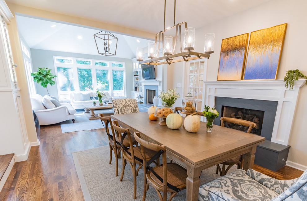 This is an example of a mid-sized transitional open plan dining in Philadelphia with beige walls, medium hardwood floors, a standard fireplace and a stone fireplace surround.
