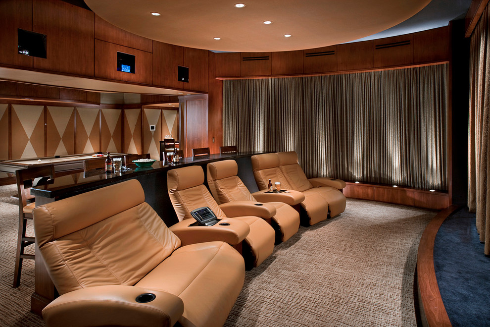 Expansive contemporary enclosed home theatre in Los Angeles with brown walls, carpet and a projector screen.