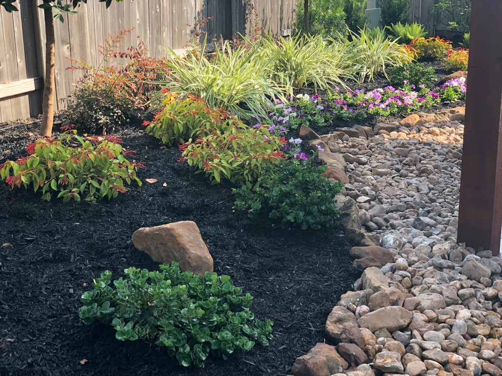 Photo of a large rustic full sun backyard concrete paver landscaping in Houston.