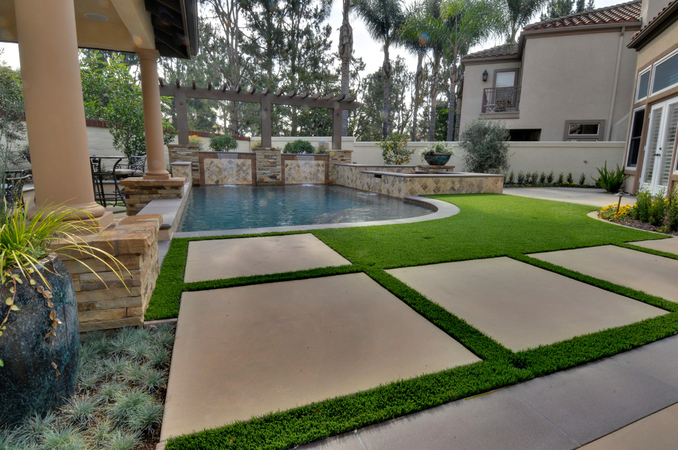 Photo of a mid-sized mediterranean backyard rectangular aboveground pool in Orange County with a water feature and concrete slab.