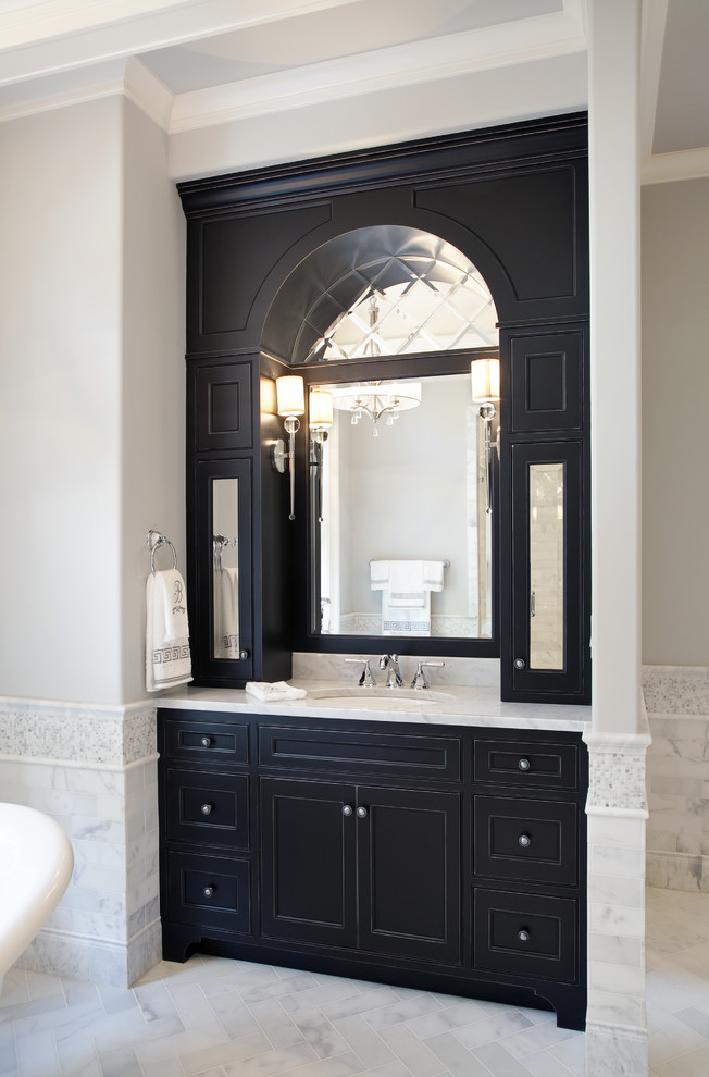 Inspiration for a large traditional master bathroom in Charleston with recessed-panel cabinets, black cabinets, a freestanding tub, white tile, marble, grey walls, marble floors, an undermount sink, marble benchtops and white floor.