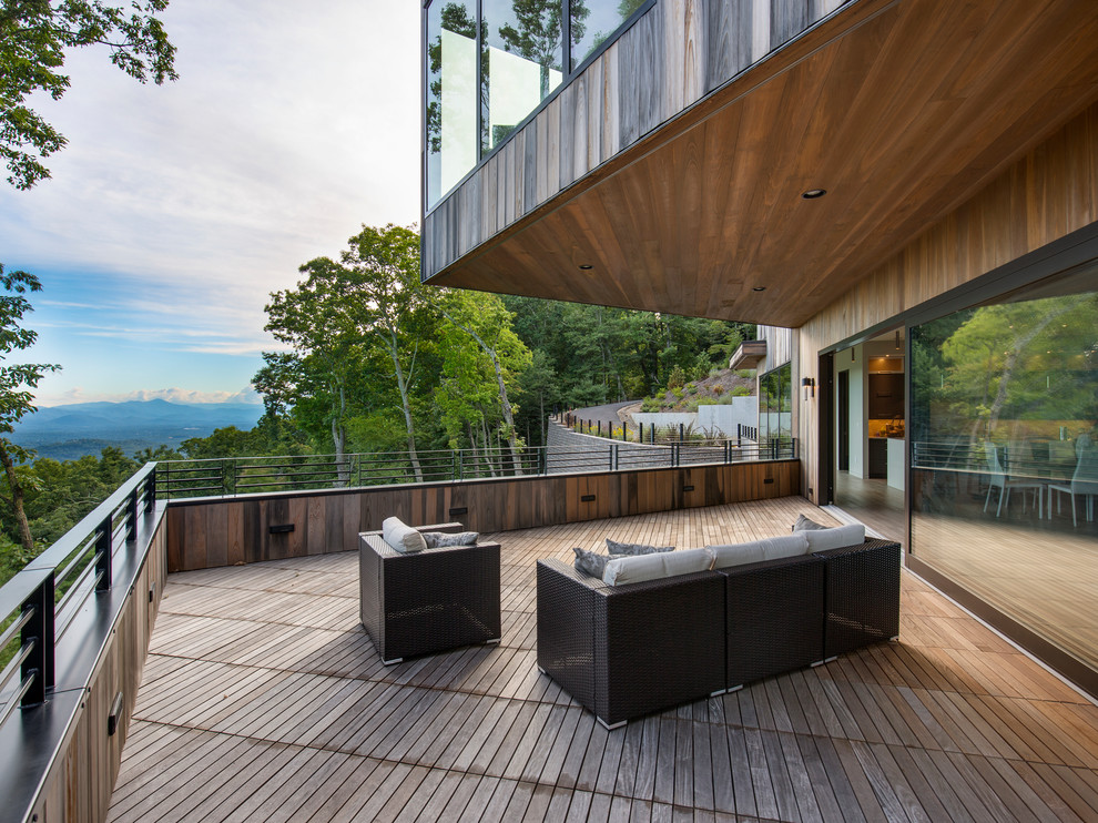 Photo of a contemporary backyard deck in Other with a roof extension.
