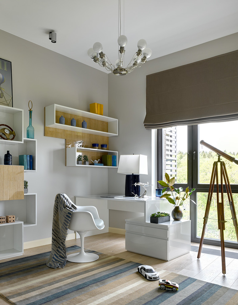 Design ideas for a contemporary kids' study room for boys in Moscow with grey walls, light hardwood floors and beige floor.