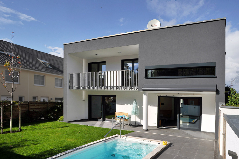 Großes, Zweistöckiges Modernes Einfamilienhaus mit Putzfassade, schwarzer Fassadenfarbe und Flachdach in Berlin