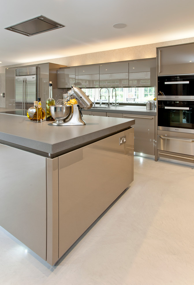 This is an example of a large contemporary kitchen in London with concrete floors.