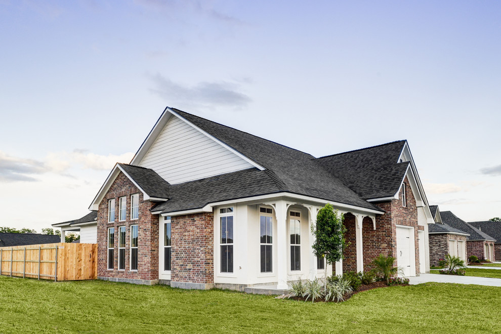 Inspiration for a mid-sized transitional one-storey brick beige house exterior in New Orleans with a shingle roof.