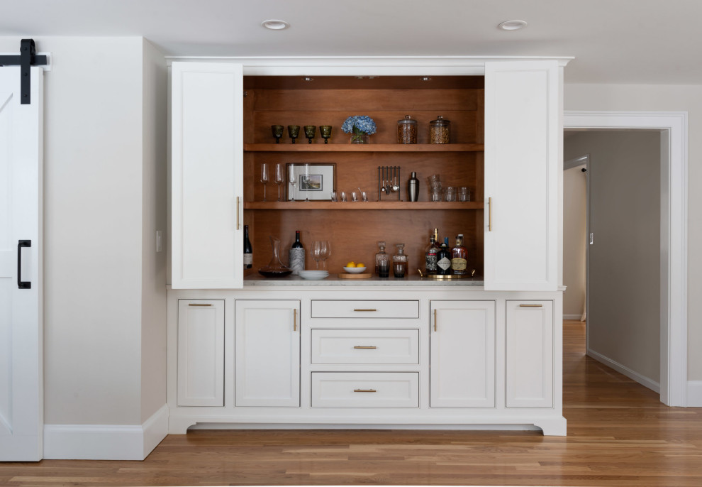 Inspiration for a mid-sized transitional single-wall home bar in Boston with shaker cabinets, white cabinets, quartzite benchtops, light hardwood floors, beige floor, white benchtop, brown splashback and timber splashback.