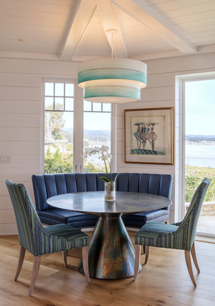 Photo of a beach style dining room in Sacramento with white walls and light hardwood floors.