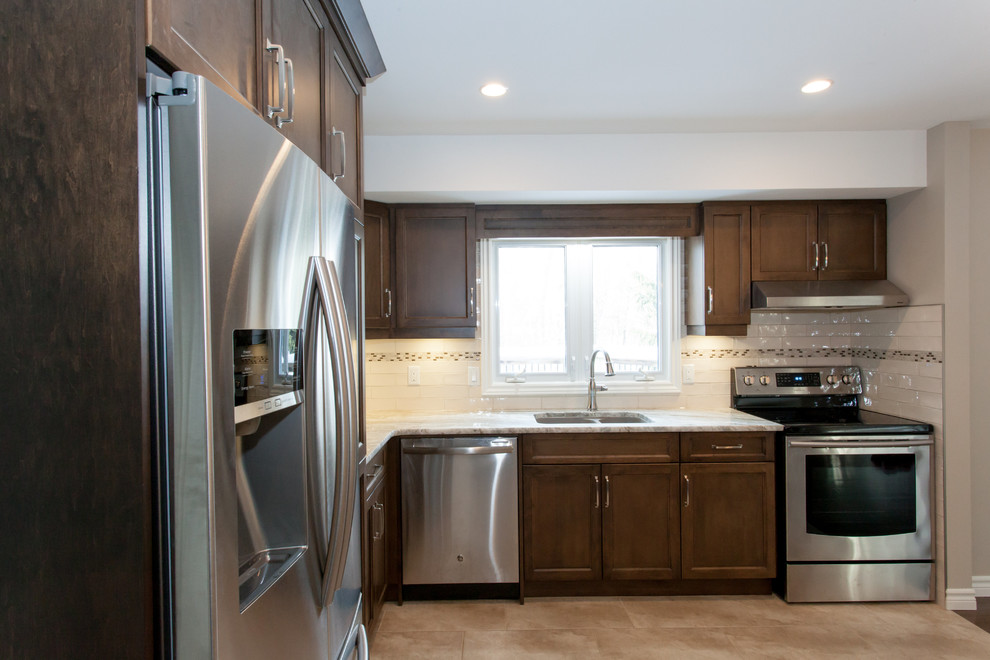 Mid-sized transitional u-shaped porcelain tile eat-in kitchen photo in Toronto with an undermount sink, recessed-panel cabinets, dark wood cabinets, granite countertops, white backsplash, porcelain backsplash, stainless steel appliances and a peninsula