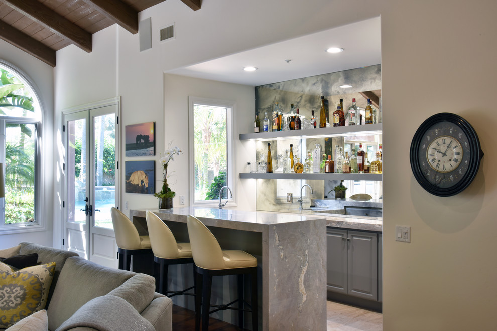 Mid-sized transitional galley seated home bar in San Diego with an undermount sink, shaker cabinets, grey cabinets, marble benchtops, mirror splashback and dark hardwood floors.