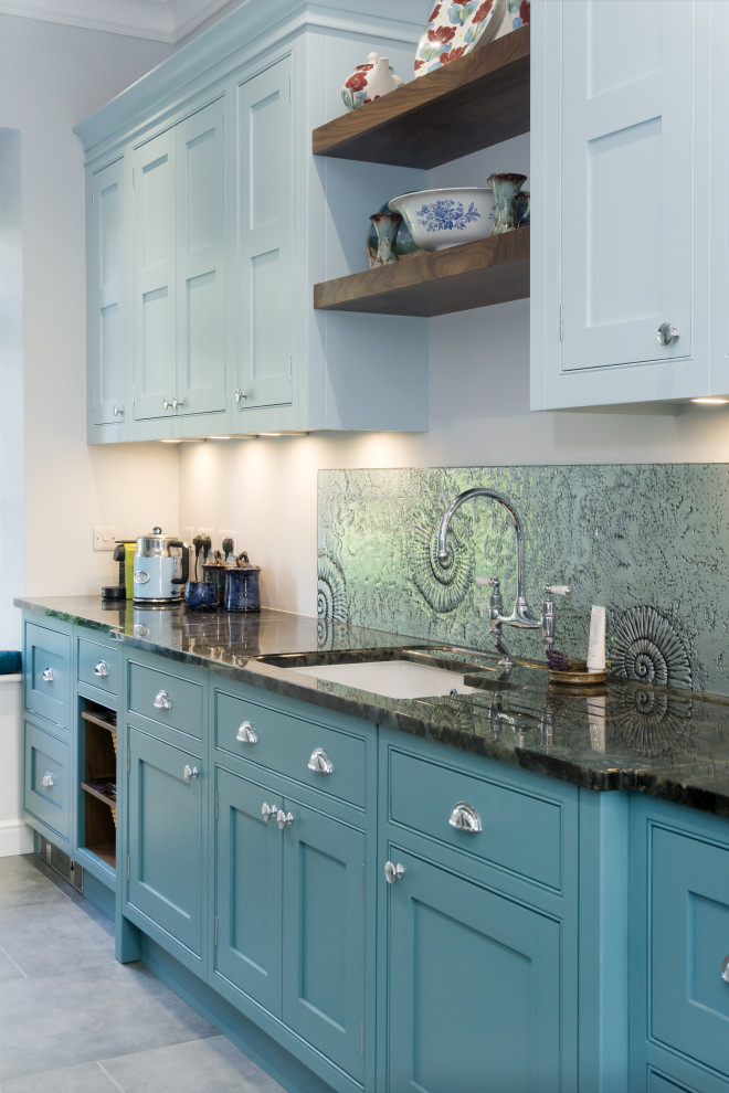 This is an example of a large transitional kitchen in Other with a drop-in sink, recessed-panel cabinets, blue cabinets, granite benchtops, glass sheet splashback, coloured appliances, ceramic floors and black benchtop.