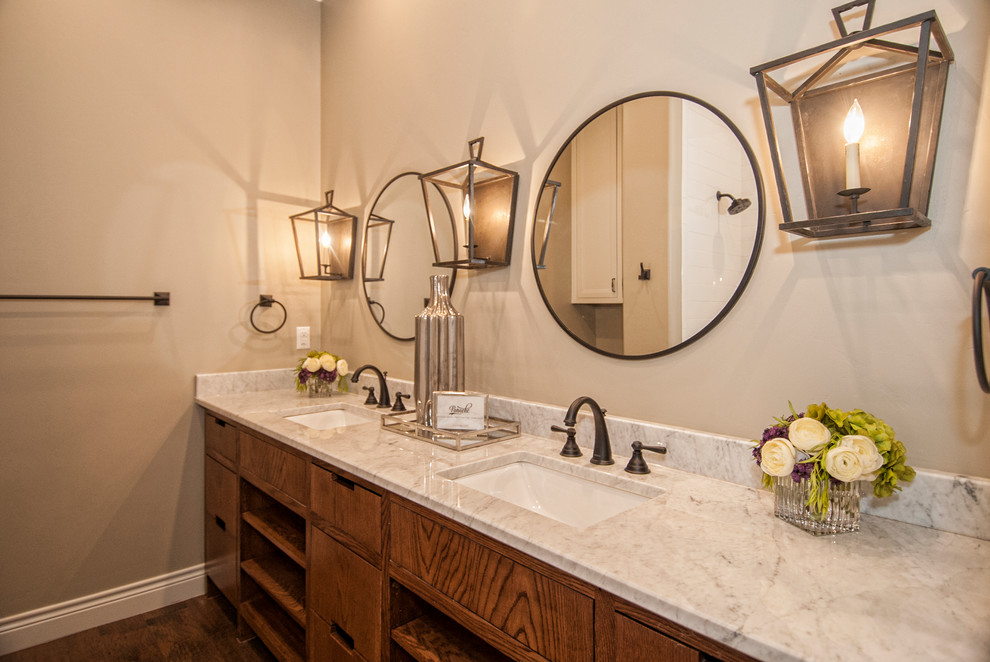 This is an example of a mid-sized transitional bathroom in Austin with flat-panel cabinets, brown cabinets, grey walls, dark hardwood floors, a drop-in sink, marble benchtops, brown floor and white benchtops.