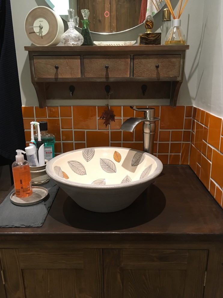 Large country 3/4 bathroom in Surrey with medium wood cabinets, brown tile, a vessel sink, wood benchtops and brown benchtops.