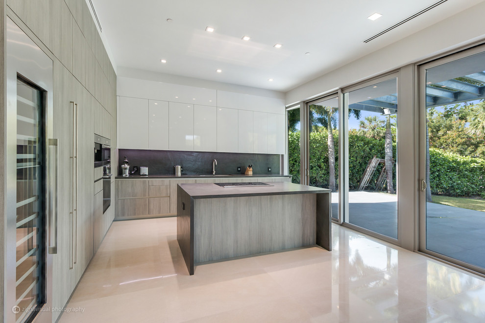 Design ideas for a large modern l-shaped kitchen in Miami with a drop-in sink, limestone benchtops, black splashback, limestone splashback, stainless steel appliances, marble floors, with island and grey floor.