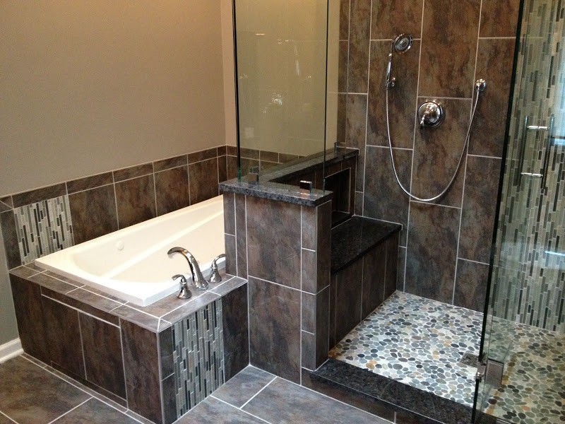 Photo of a mid-sized transitional 3/4 bathroom in Chicago with flat-panel cabinets, black cabinets, a corner tub, an open shower, a one-piece toilet, black tile, ceramic tile, beige walls, ceramic floors, a pedestal sink, grey floor and an open shower.