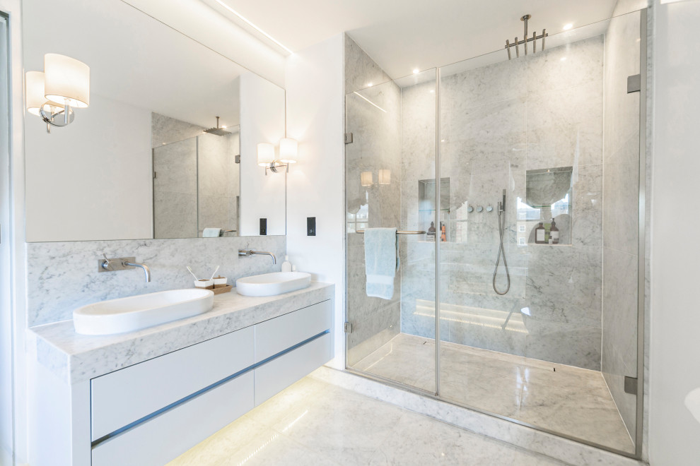 Large contemporary master bathroom in London with flat-panel cabinets, white cabinets, an alcove shower, gray tile, white walls, a vessel sink, grey floor, a hinged shower door, grey benchtops, a niche and a floating vanity.