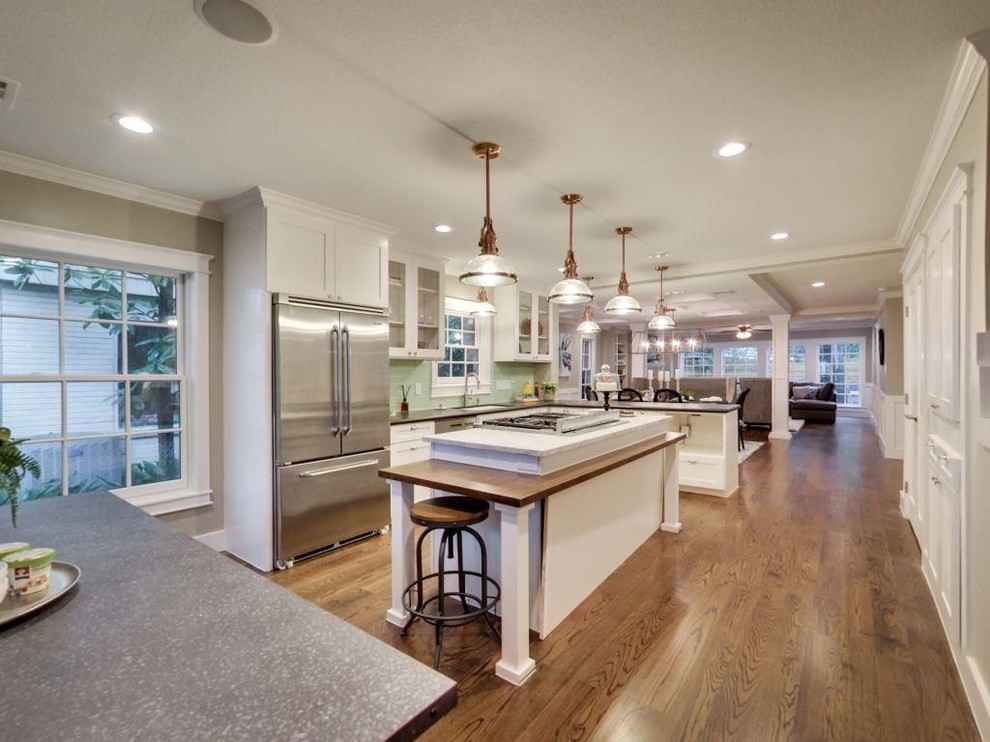 Eat-in kitchen - mid-sized transitional l-shaped medium tone wood floor and brown floor eat-in kitchen idea with an undermount sink, glass-front cabinets, white cabinets, solid surface countertops, green backsplash, subway tile backsplash, stainless steel appliances and an island