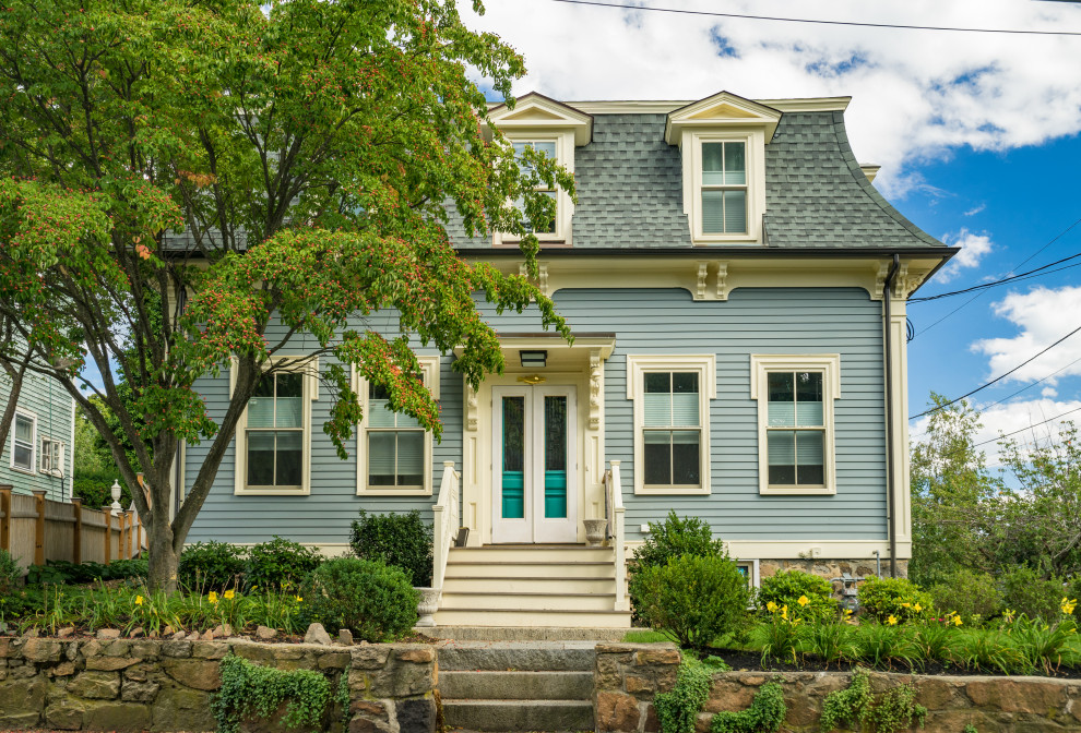 This is an example of a traditional two-storey blue house exterior in Boston with a shingle roof.