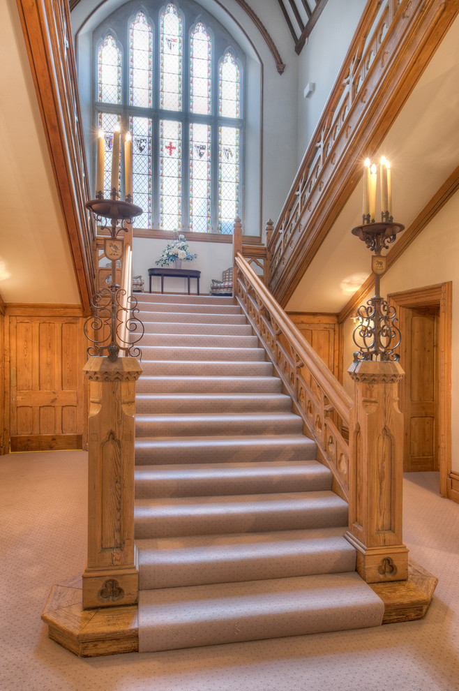 This is an example of an expansive midcentury carpeted staircase in Devon with carpet risers.