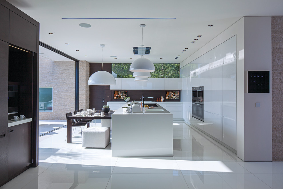 This is an example of a contemporary l-shaped eat-in kitchen in Los Angeles with a double-bowl sink, flat-panel cabinets, white cabinets, stainless steel appliances and white floor.