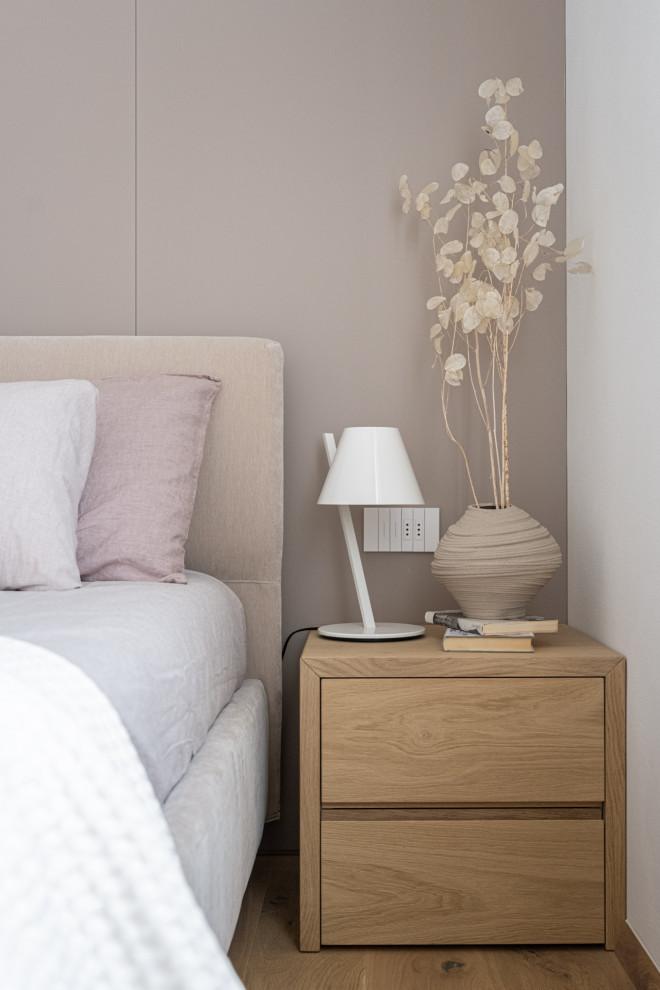 Ejemplo de dormitorio principal minimalista con paredes blancas, suelo de madera clara, suelo marrón, bandeja y boiserie