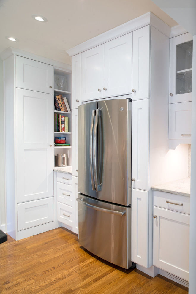 Example of a mid-sized transitional u-shaped medium tone wood floor eat-in kitchen design with an undermount sink, shaker cabinets, white cabinets, granite countertops, gray backsplash, mosaic tile backsplash, colored appliances and an island