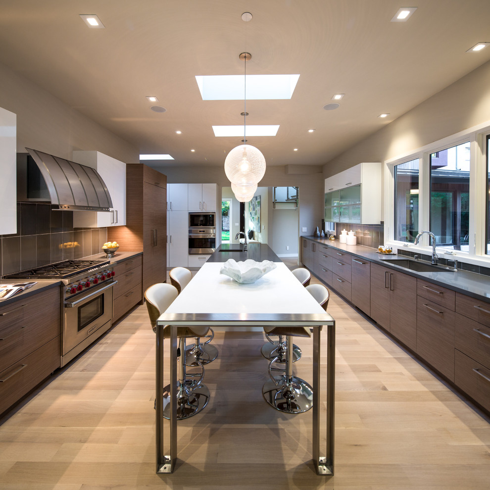 Photo of a large contemporary galley separate kitchen in San Francisco with flat-panel cabinets, medium wood cabinets, with island, quartz benchtops, grey splashback, light hardwood floors, stainless steel appliances, an integrated sink, porcelain splashback and beige floor.