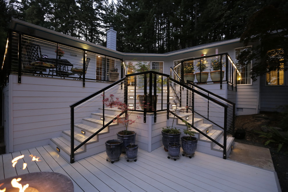 Photo of a large modern backyard deck in Other with a fire feature and no cover.