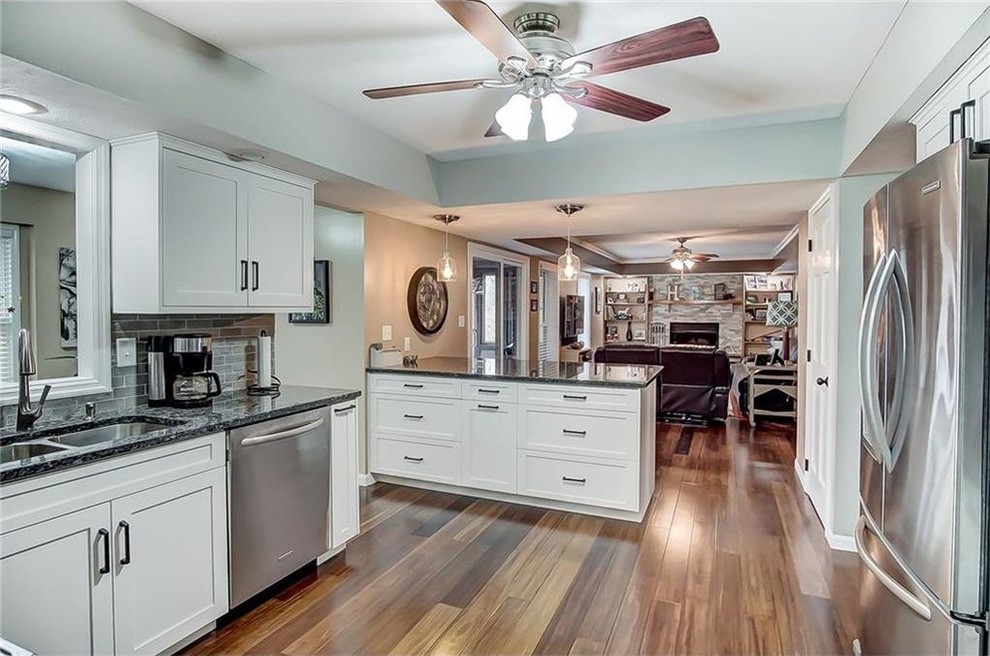 Inspiration for a transitional medium tone wood floor kitchen remodel with shaker cabinets, white cabinets and granite countertops