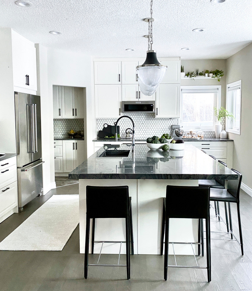Eat-in kitchen - large transitional l-shaped medium tone wood floor and gray floor eat-in kitchen idea in Calgary with an undermount sink, shaker cabinets, white cabinets, quartzite countertops, white backsplash, ceramic backsplash, stainless steel appliances, an island and gray countertops