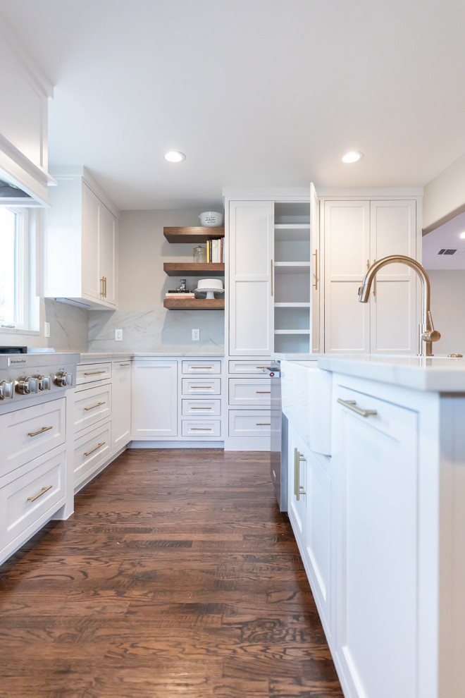 Inspiration for a mid-sized transitional u-shaped kitchen in Dallas with a farmhouse sink, shaker cabinets, yellow cabinets, quartzite benchtops, white splashback, stone slab splashback, stainless steel appliances, dark hardwood floors, with island, brown floor and white benchtop.