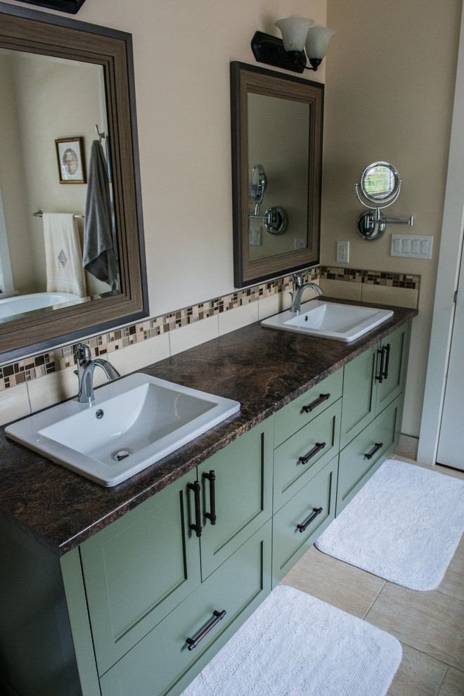 Photo of a mid-sized country master bathroom in Vancouver with shaker cabinets, green cabinets, multi-coloured tile, beige walls and laminate benchtops.