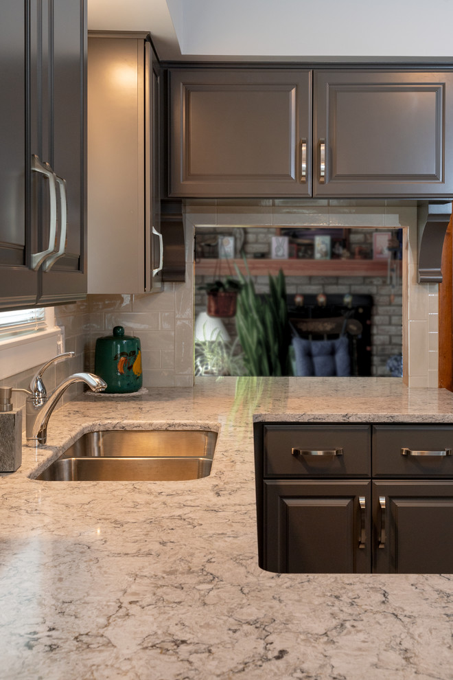 Small transitional u-shaped vinyl floor and gray floor eat-in kitchen photo with a double-bowl sink, raised-panel cabinets, gray cabinets, quartz countertops, white backsplash, subway tile backsplash, white appliances, no island and multicolored countertops