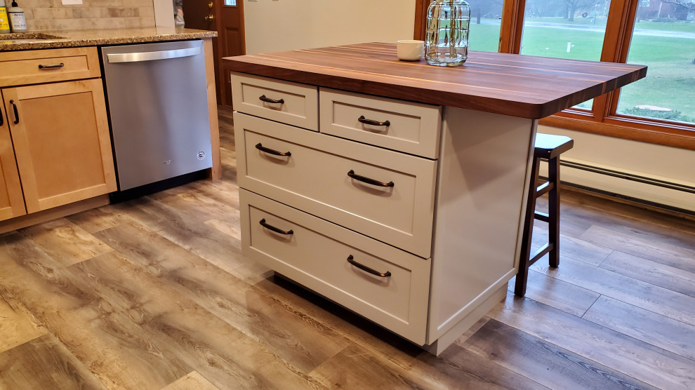 Example of a mid-sized mountain style u-shaped vinyl floor and gray floor enclosed kitchen design with an undermount sink, shaker cabinets, light wood cabinets, quartz countertops, beige backsplash, stone tile backsplash, stainless steel appliances, an island and multicolored countertops