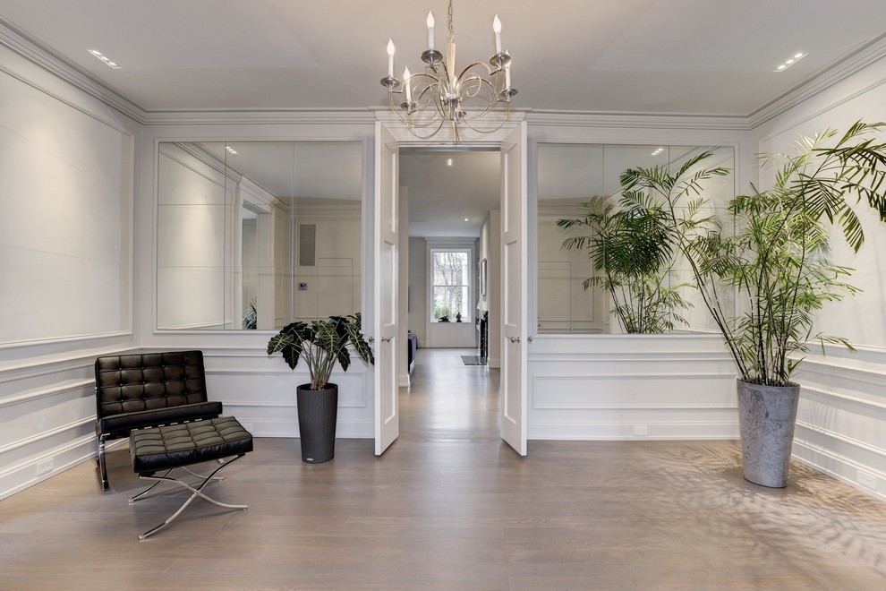Example of a huge transitional light wood floor double front door design in DC Metro with white walls and a white front door